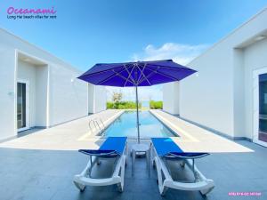 - une piscine avec une table, des chaises et un parasol dans l'établissement Villa 1602 Oceanami, Sát biển, Hồ bơi riêng, 837m2, à Long Hải