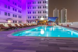 a swimming pool in a hotel at night at Elite Crystal Hotel in Manama