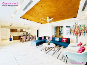 ein Wohnzimmer mit einem blauen Sofa und einem Tisch in der Unterkunft Villa 1602 Oceanami, Sát biển, Hồ bơi riêng, 837m2 in Long Hải