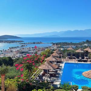 a view of a resort with a swimming pool and the ocean at Elounda Heights (Adults Only) in Elounda