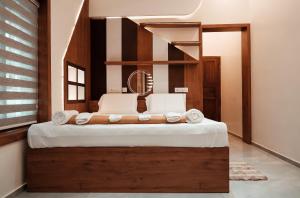 una camera da letto con un letto con lenzuola e asciugamani bianchi di Kalloos Island Backwater Resort a Kollam