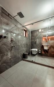 a bathroom with a glass shower and a sink at Kalloos Island Backwater Resort in Kollam