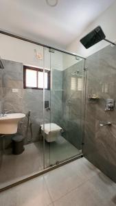 un bagno con doccia in vetro e lavandino di Kalloos Island Backwater Resort a Kollam