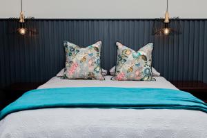 een bed met 2 kussens en een blauwe deken bij 2 Owls Guesthouse in Potchefstroom