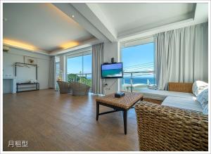 a living room with a couch and a large window at My Ocean Villa 月牙桐海景民宿 in Ruifang