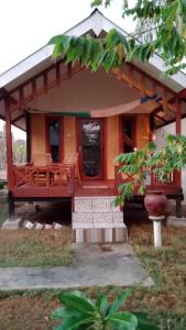 a small house with a porch and a table at Why Not Bar And Bungalows #2 in Pawenang
