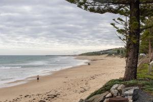 a beach with people walking on the sand at Cozy Getaway, King Bed with TV, NBN, Netflix, Nespresso in Christies Beach