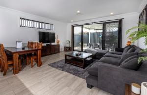 a living room with a couch and a table at Cozy Getaway, King Bed with TV, NBN, Netflix, Nespresso in Christies Beach