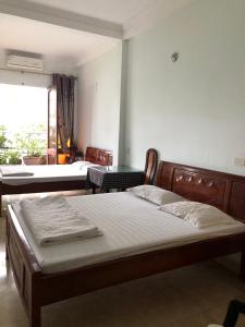 a bedroom with two beds and a window at Nhà Nghỉ Hương Thúy - TTTM Royal City in Hanoi