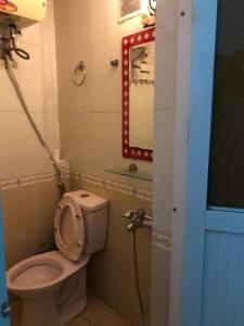 een kleine badkamer met een toilet en een spiegel bij Nhà Nghỉ Hương Thúy - TTTM Royal City in Hanoi