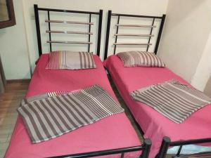 two bunk beds in a room with pink sheets at George Dom in Batumi