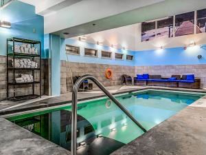 a swimming pool in a room with a couch and a couch at Rockies Retreat by Canadian Rockies Vacation Rentals in Canmore