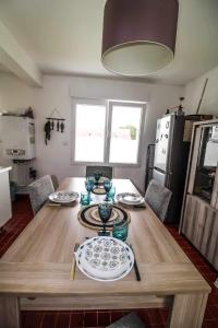 una mesa de madera con platos en la cocina en Dunes et Mer, en Plage Sainte-Cécile
