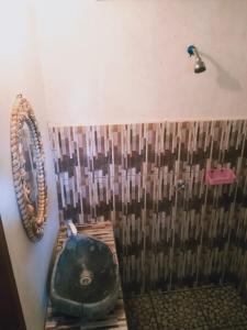 a bathroom with a shower with a toilet and a sink at Why Not Bar And Bungalows #3 in Pawenang