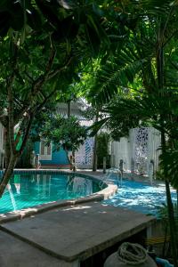 een zwembad met bomen op de voorgrond bij Deeden Pattaya Resort in Pattaya South