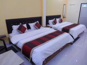 2 camas en una habitación de hotel con 2 colchas en Ranthambhore Tiger Hut, en Sawāi Mādhopur