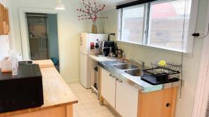 a kitchen with a sink and a refrigerator at Fanny Phillips Cottage in Beechworth
