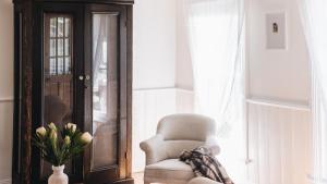 ein Wohnzimmer mit einem Stuhl und einer Vase aus Blumen in der Unterkunft Picketts Cottage in Beechworth