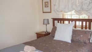 a bedroom with a bed with a pillow and a window at Hildas At Beechworth in Beechworth