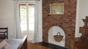 a brick fireplace in a room with a window at Hildas At Beechworth in Beechworth