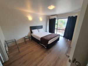 a bedroom with a bed and a large window at Ascot Epsom Motel in Auckland