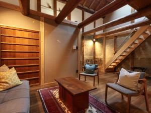 a living room with a couch and two chairs at NIPPONIA 田原本 マルト醤油 in Nara