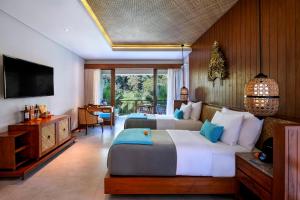 a hotel room with two beds and a television at Aksari Resort Ubud by Ini Vie Hospitality in Tegalalang