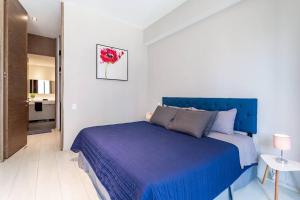 a bedroom with a blue bed in a white room at Moderno Departamento en Reforma 284 in Mexico City +13 photos