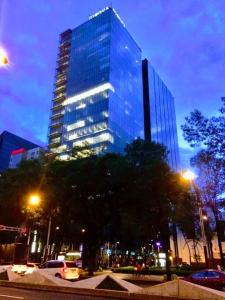 a tall glass building in a city at night at Moderno Departamento en Reforma 284 in Mexico City