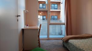 sypialnia z oknem, biurkiem i łóżkiem w obiekcie Stockholm Private Rooms in Shared Lovely, Amazing, Modern Apartment +Garden +BBQ w Sztokholmie