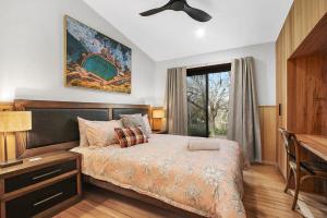 a bedroom with a bed and a desk and a window at Millie & Pips Beechworth Bungalow in Beechworth