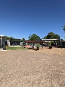 un estacionamiento de grava con un pabellón en el fondo en Kaputar Motel, en Narrabri