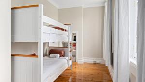 a white bedroom with a bunk bed in it at 1858 - The Prospect in Beechworth