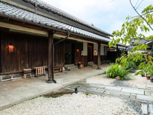 a wooden house with a pathway leading to it at NIPPONIA 田原本 マルト醤油 in Nara