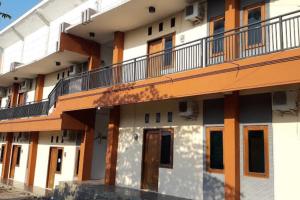 un edificio de apartamentos de color naranja y blanco en OYO Life 92647 Edelweis Homestay, en Tuban
