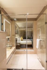 a master bathroom with a bed and a shower at Regenta Central Javaji Mysore in Mysore
