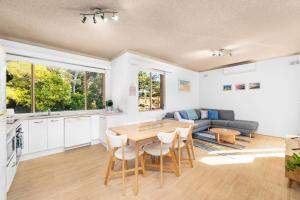 a kitchen and living room with a table and chairs at Del Rae Unit 15 25 Shoal Bay Road in Shoal Bay