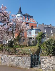 a large house on a hill with a tree at Altbauwohnung in Gründerzeitvilla in Wuppertal