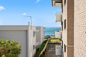 an alley between two buildings with the ocean in the background at Del Rae Unit 15 25 Shoal Bay Road in Shoal Bay