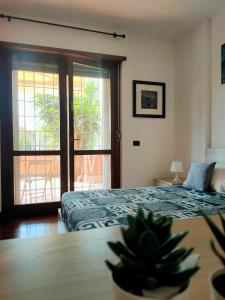 Un dormitorio con una cama y una puerta corrediza de vidrio. en Lele House Fiumicino - Intero Appartamento Aeroporto di Fiumicino - Nuova Fiera di Roma, en Fiumicino