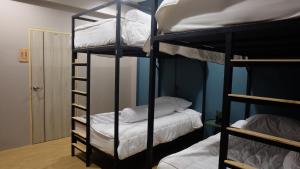 Camera con 2 letti a castello e cuscini bianchi di A lazy person hostel a Chumphon