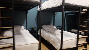 1 Schlafzimmer mit 2 Etagenbetten und weißen Kissen in der Unterkunft A lazy person hostel in Chumphon