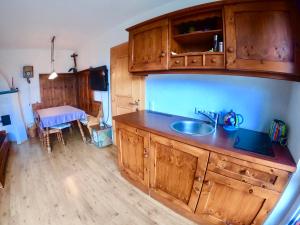 cocina con armarios de madera, fregadero y mesa en The Mountain View Innsbruck, en Innsbruck
