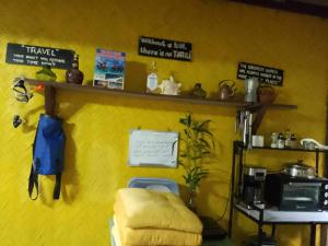 a yellow room with a yellow wall with a shelf at Camp Talusi Hilltop Overlooking in El Nido