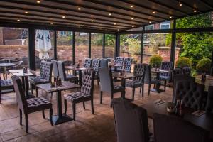 a restaurant with tables and chairs on a patio at The George Wright Boutique Hotel, Bar & Restaurant in Rotherham