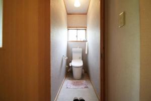 a small bathroom with a toilet and a window at 南阿蘇Villagehouseらかん in Minami Aso +16 photos