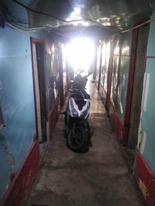 a scooter parked in a hallway in a building at SPOT ON 93104 Barak Tambunan in Medan
