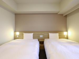 Ένα ή περισσότερα κρεβάτια σε δωμάτιο στο Dormy Inn Hiroshima Annex