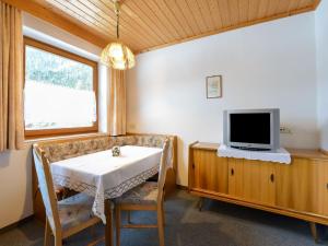 ロイタッシュにあるSuperb Apartment in Leutasch Tyrol with Meadow aroundのダイニングルーム(テーブル、テレビ付)