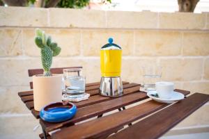 un tavolo in legno con macchinetta del caffè e cactus. di Il casalicchio for families a Montalbano